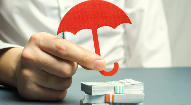 Red umbrella covering stacks of bills