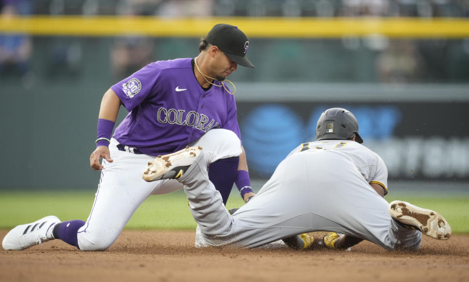 Colorado Rockies shortstop Ezequiel Tovar, left, applies a late tag as Pittsburgh Pirates' Ke'Bryan Hayes slides safely into second base with an RBI-double in the second inning of a baseball game Monday, April 17, 2023, in Denver. (AP Photo/David Zalubowski)