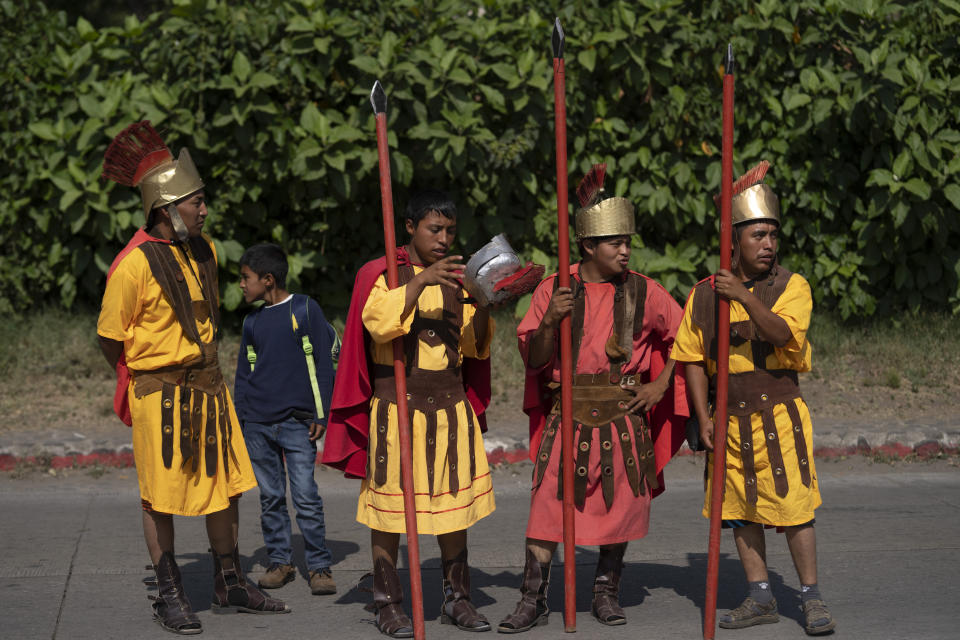 Fieles disfrazados de soldados romanos participan en una procesión afuera de la iglesia católica San Cristóbal el Bajo en Antigua, Guatemala, el jueves 6 de abril de 2023. (AP Foto/Moises Castillo)