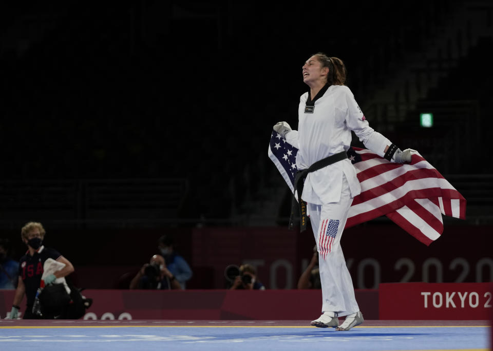 United States's Anastasija Zolotic celebrates as she holds her country national flag after winning a gold medal for the taekwondo women's 57kg match at the 2020 Summer Olympics, Sunday, July 25, 2021, in Tokyo, Japan. (AP Photo/Themba Hadebe)