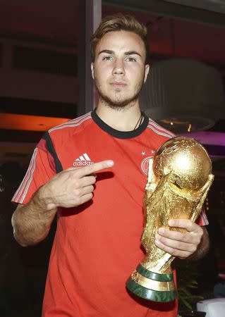 El mediocampista alemán Mario Götze posa junto a la Copa del Mundo de la FIFA en una fiesta de gala organizada por la federación alemana de fútbol en Río de Janeiro, jul 13 2014. REUTERS