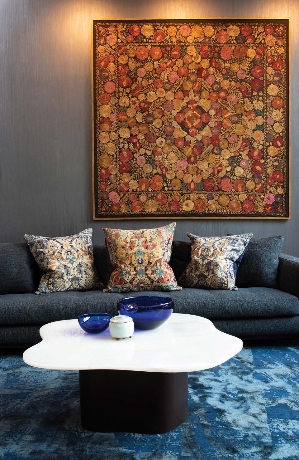 living room with grey wall, blue sofa and blue rug