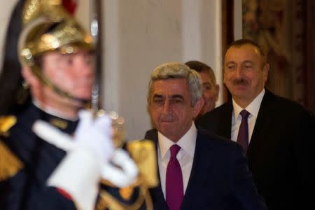 Armenia's President Serzh Sargsyan (C) and Azerbaijan's President Ilham Aliyev (R) leave after a dinner with French President Francois Hollande, to discuss the conflict around Nagorno-Karabakh, at the Elysee Palace in Paris October 27, 2014. REUTERS/Philippe Wojazer