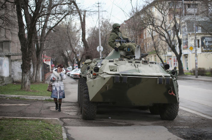 A woman walks past a Russian military personnel carrier outside a Ukrainian military base on March 18, 2014 in Simferopol, Ukraine. Voters on the autonomous Ukrainian peninsular of Crimea voted overwhelmingly yesterday to secede from their country and join Russia.<span class="copyright">Dan Kitwood—Getty Images</span>