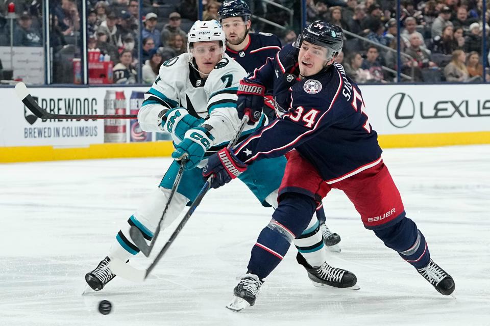 Jan 21, 2023; Columbus, Ohio, USA;  Columbus Blue Jackets center Cole Sillinger (34) shoots past San Jose Sharks center Nico Sturm (7) during the third period of the NHL hockey game at Nationwide Arena. The Blue Jackets won 5-3. Mandatory Credit: Adam Cairns-The Columbus Dispatch