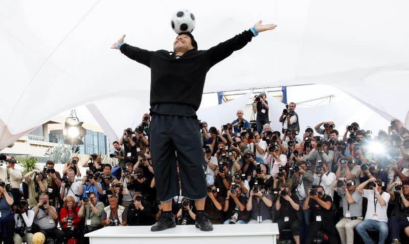 FILE PHOTO: Former soccer star Maradona balances a ball on his head during a photocall at the 61st Cannes Film Festival