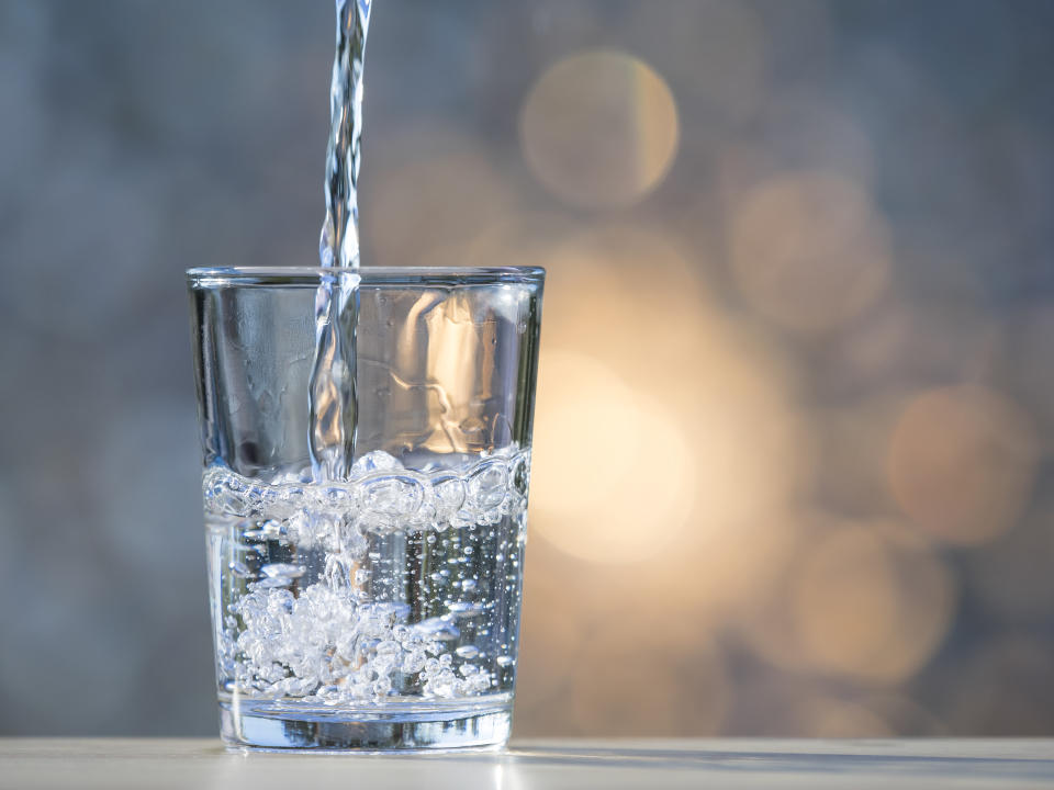 Water jet filling a glass of crystal.