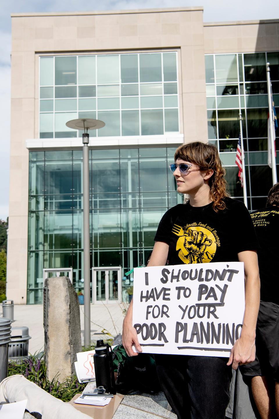 Karli Schwartz listens to speakers during an Asheville Food and Beverage United rally at the Buncombe County Courthouse September 6, 2022. The group asked local government to provide free parking or parking at a reduced rate for downtown workers, who may spend between $100-$400 per month on parking.