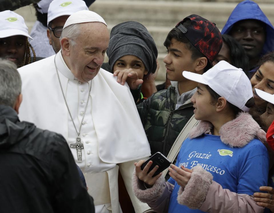 Pope Francis meets a group of migrants recently arrived from Libya, wearing shirts with writing reading "Thank you Pope Francis, at the end of his weekly general audience in St. Peter's Square, at the Vatican, Wednesday May 15, 2019. (AP Photo/Andrew Medichini)
