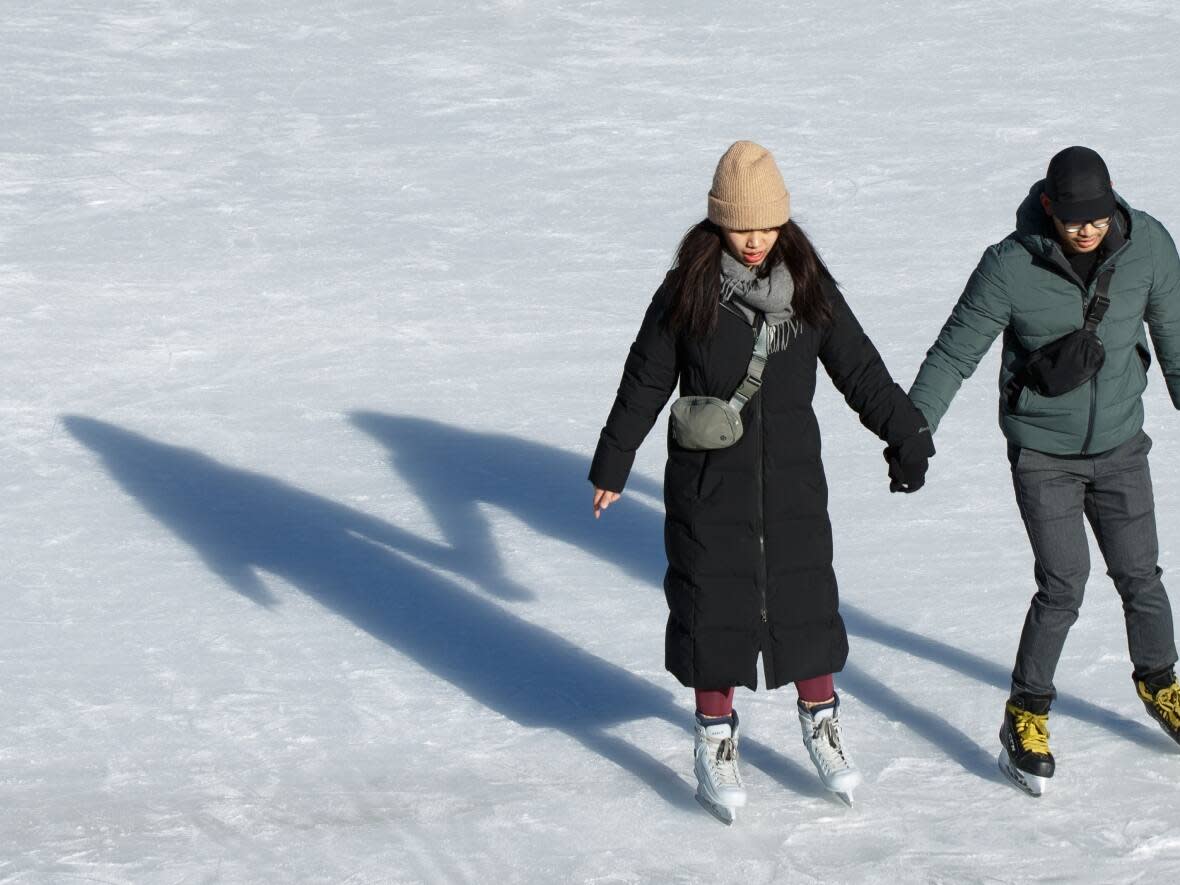 People skate on the refrigerated ice rink at Nathan Phillips Square in Toronto on Feb. 23, 2023. Across much of Eastern Canada this year, the winter has been too warm for natural ice rinks. (Alex Lupul/CBC - image credit)