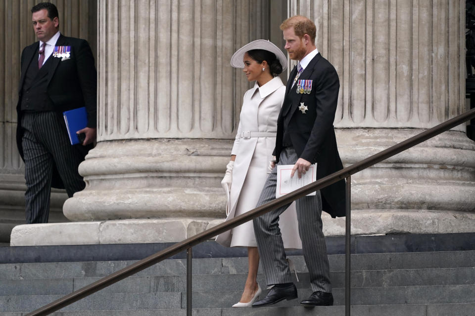 El príncipe Enrique y su esposa Meghan, duquesa de Sussex, salen tras asistir a una misa de acción de gracias para la reina Isabel II en la Catedral de San Pablo en Londres el viernes 3 de junio de 2022 en el segundo de cuatro días de celebraciones por su Jubileo de Platino por sus 70 años de reinado. (Foto AP/Alberto Pezzali)