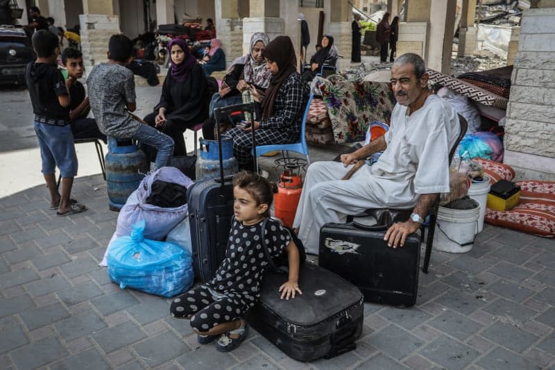 Palestinians carry their belongings as they flee Hamad City towards Al-Mawasi after the Israeli army dropped leaflets demanding that residents of a northern neighborhood in Khan Younis evacuate immediately ahead of a new military operation in the Gaza Strip. Abed Rahim Khatib/dpa