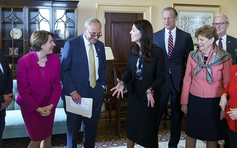 Amy Klobuchar, Charles Schumer and Jacinda Ardern of New Zealand laugh at a joke during a photo op with other lawmakers