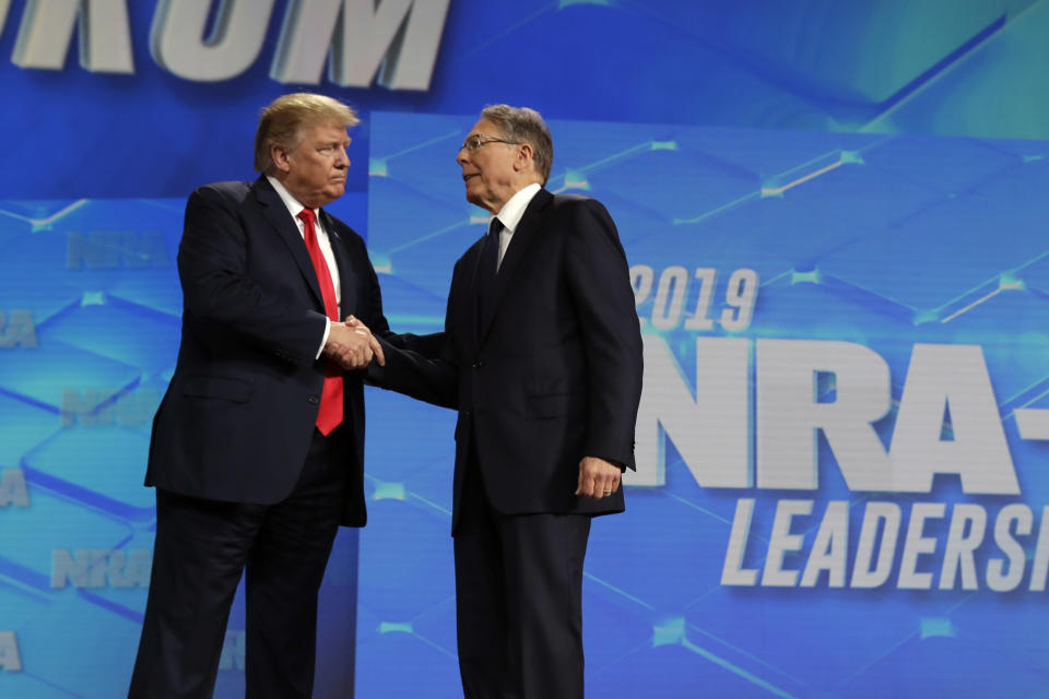 FILE - President Donald Trump shakes hands with NRA executive vice president and CEO Wayne LaPierre, has he arrives to speak to the annual meeting of the National Rifle Association, Friday, April 26, 2019, in Indianapolis. The National Rifle Association is going ahead with its annual meeting in Houston just days after the shooting massacre at a Texas elementary school that left 19 children and 2 teachers dead. With protests planned outside, former President Donald Trump and other leading GOP figures, including South Dakota Gov. Kristi Noem, will address attendees. (AP Photo/Evan Vucci, File)