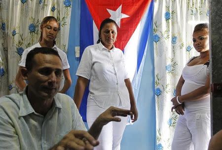 Cuban dissident Jose Daniel Ferrer gives an interview to Reuters as his wife Belkis Cantillo (C), daughter Martha (L) and other relative Yasnay listen inside their home in Palmarito de Cauto March 25, 2012. REUTERS/Mariana Bazo/Files