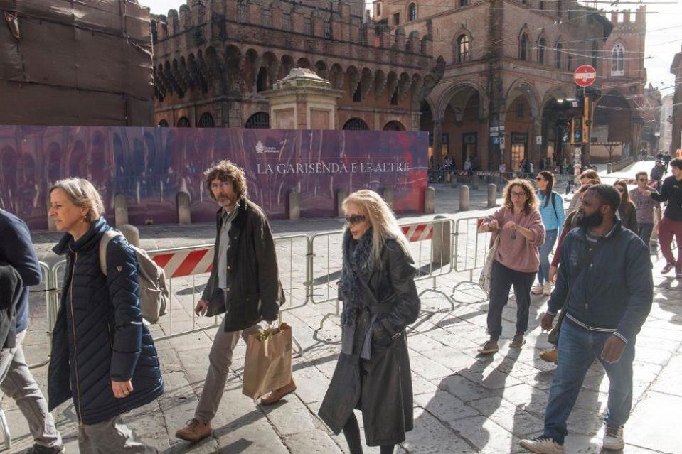 Personas caminando al lado de barreras de metal