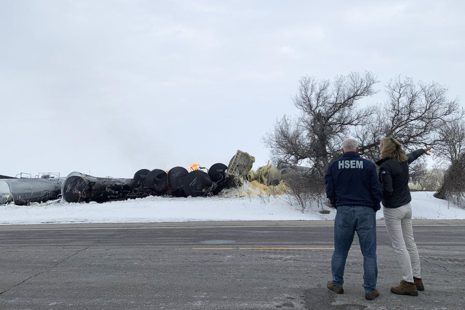 In this photo provided by the office of Minnesota Gov. Tim Walz, Walz visits the site of a fiery train derailment on Thursday, March 30, 2023, in Raymond, Minn. The early morning derailment spilled ethanol, which caught fire and prompted residents within a half-mile radius of the incident to evacuate. Walz, left, is pictured with Katie Farmer, the CEO of BNSF Railway. (Teddy Tschann/Office of Minnesota Gov. Tim Walz via AP)