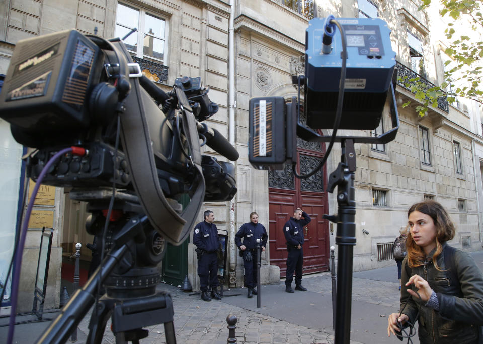 FILE - In this Monday, Oct. 3, 2016 file photo, French police officers and a TV crew stand outside the residence of Kim Kardashian West in Paris. In October 2016, robbers allegedly forced their way into the apartment where Kim Kardashian West was staying during Paris Fashion Week, tied her up and stole more than $10 million worth of jewelry. A brazen burglary on Monday Nov. 25, 2019 from Dresden’s Green Vault, one of the world’s oldest museums, holding priceless treasures is another in a long history of daring European heists over the years. (AP Photo/Michel Euler, File)