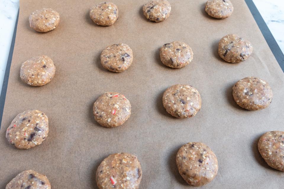 Flattened peppermint chocolate chunk dough balls on parchment paper