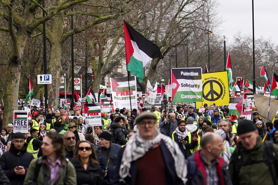 FILE - Protesters hold up flags and placards during a demonstration in support of Palestinian people in Gaza, in London, on Feb. 17, 2024. The British government published an official definition of “extremism” on Thursday, March 14, 2024 and said groups that get the label will be barred from receiving government funding. Mass pro-Palestinian protests have drawn hundreds of thousands of people to central London to call for a cease-fire. The protests have been overwhelmingly peaceful, though there have been dozens of arrests over signs and chants that police say showed support for the militant Hamas group, a banned organization in Britain. (AP Photo/Alberto Pezzali, File)