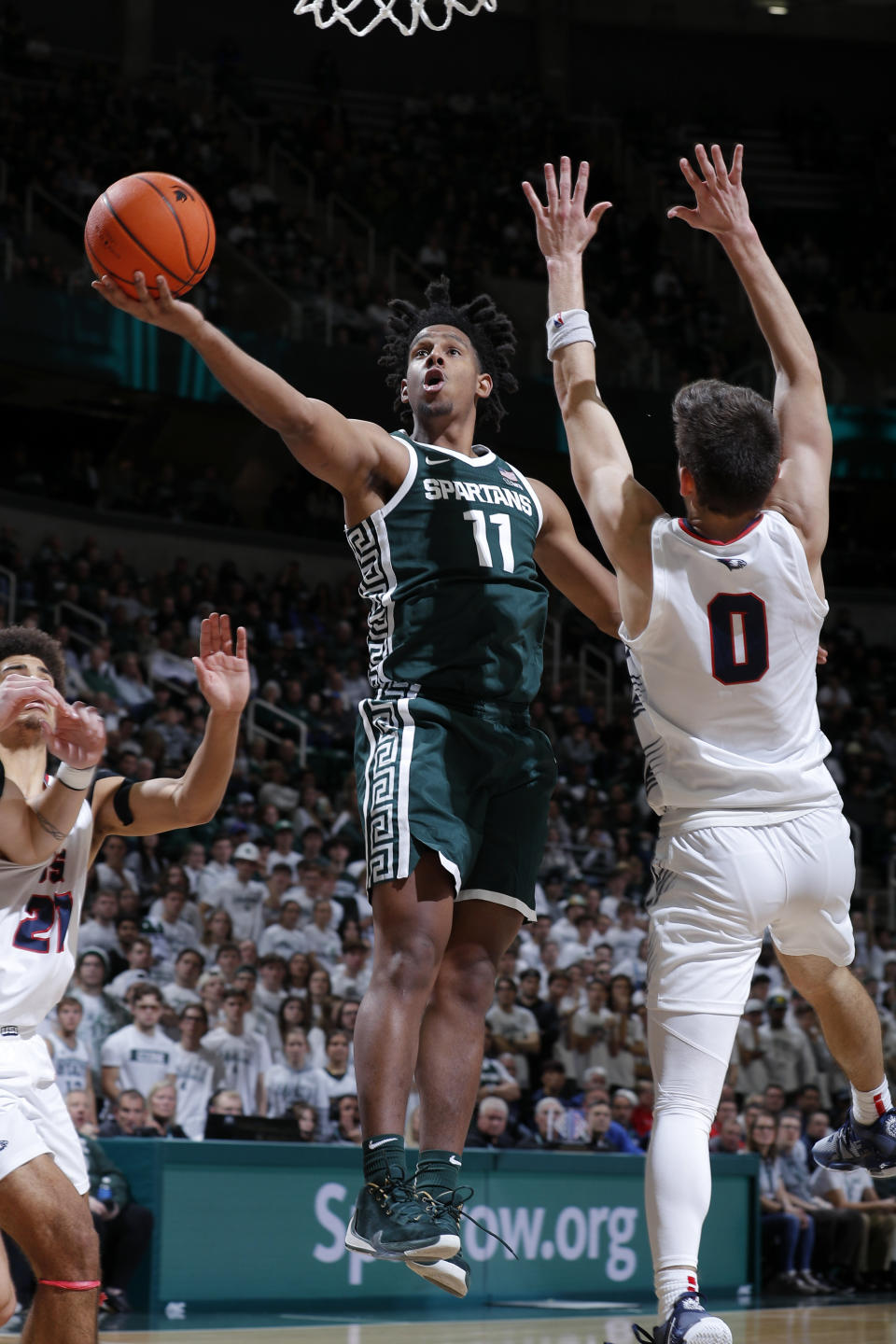 Michigan State's A.J. Hoggard, left, shoots against Southern Indiana's Ryan Hall (0) during the second half of an NCAA college basketball game, Thursday, Nov. 9, 2023, in East Lansing, Mich. (AP Photo/Al Goldis)