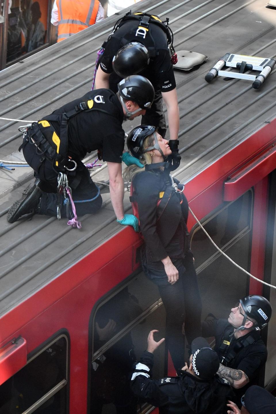 A climate protester is removed from the top of the DLR train (AFP/Getty Images)