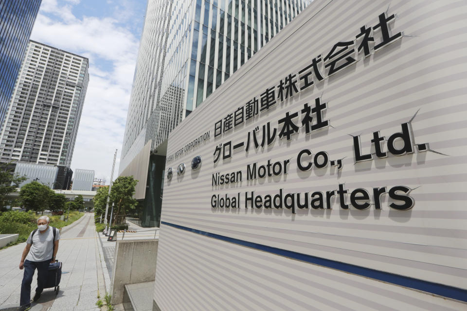 A man walks past Nissan Motor Co.'s global headquarters in Yokohama, near Tokyo, Tuesday, June 22, 2021. Nissan Chief Executive Makoto Uchida pleaded for patience from disgruntled shareholders Tuesday, promising a turnaround at the Japanese automaker, which is projecting a third year of losses as it struggles to distance itself from a scandal over its former Chairman Carlos Ghosn. (AP Photo/Koji Sasahara)