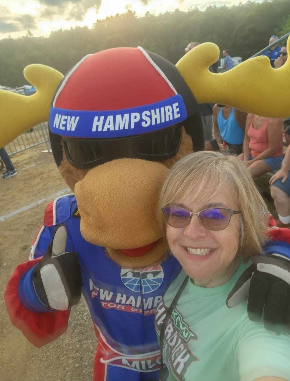 Min Kennett pauses from Fan Zone activity to get a photo with New Hampshire Motor Speedway mascot Milo the Moose.