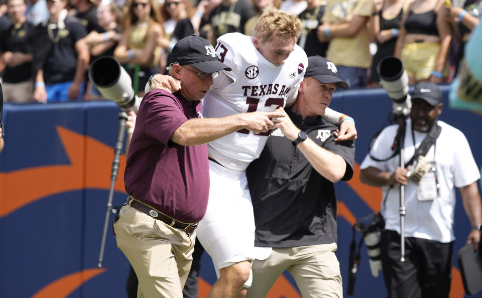 Texas A&M quarterback Haynes King, center, is helped off the field after being injured in the first half of an NCAA college football game against Colorado, Saturday, Sept. 11, 2021, in Denver. (AP Photo/David Zalubowski)