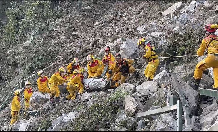 En esta foto tomada el jueves 4 de abril de 2024, y publicada por el Departamento de Bomberos de Pingtung, bomberos evacuan un cuerpo del Parque Nacional Taroko un día después de que un poderoso terremoto golpeara el condado de Hualien, en el este de Taiwán.