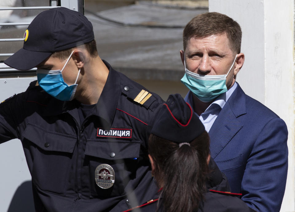 A governor of the Khabarovsk region along the border with China, Sergei Furgal, right, is escorted from a court room in Moscow, Russia, Friday, July 10, 2020. A provincial governor in Russia's far east has been arrested on charges of involvement in multiple murders and was flown to Moscow. The court ordered Frugal to be jailed for two months as the investigation continues. (AP Photo/Alexander Zemlianichenko)