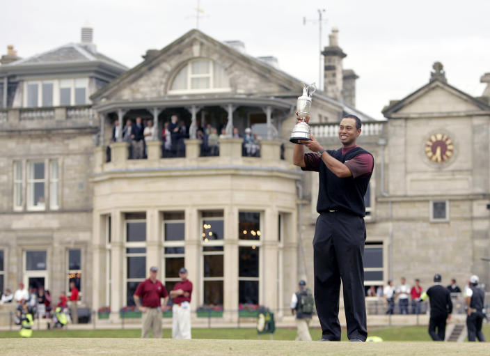 FILE - Tiger Woods holds the trophy as he stands in front of the clubhouse after winning the British Open golf championship on the Old Course at St. Andrews, Scotland, Sunday July 17, 2005. The Open Championship returns to the home of golf on July 14-17, 2022, to celebrate the 150th edition of the sport's oldest championship, which dates to 1860 and was first played at St. Andrews in 1873. (AP Photo/Alastair Grant, File)