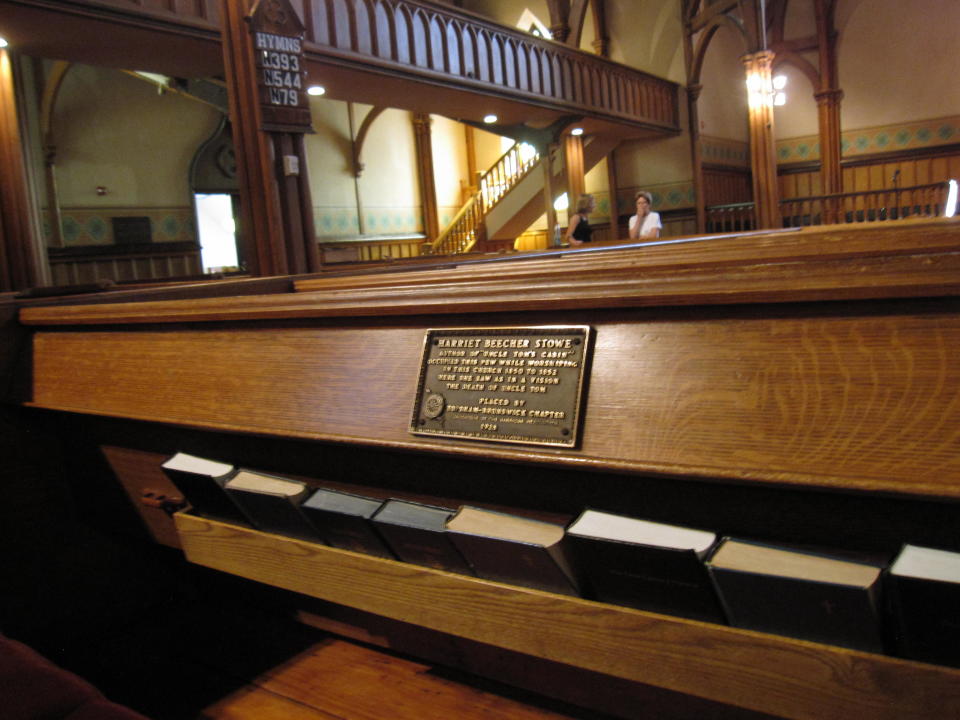 This July 13, 2012 photo shows the marker on a pew at First Parish Church in Brunswick, Maine, where “Uncle Tom’s Cabin” author Harriet Beecher Stowe sat in 1851 when she had a vision of a scene for the book. The church, a Gothic Revival building that dates to the 1840s, is one of 14 sites in Brunswick on the National Register of Historic Places. (AP Photo/Beth Harpaz)