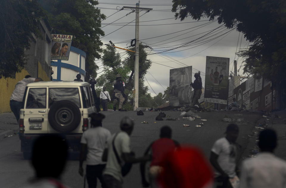 A group of journalists approach a police station where colleague Romelo Vilsaint was fatally shot, in Port-au-Prince, Haiti, Sunday, Oct. 30, 2022. Vilsaint died Sunday after being shot in the head when police opened fire on reporters demanding the release of one of their colleagues who was detained while covering a protest, witnesses told The Associated Press. (AP Photo/Ramon Espinosa)