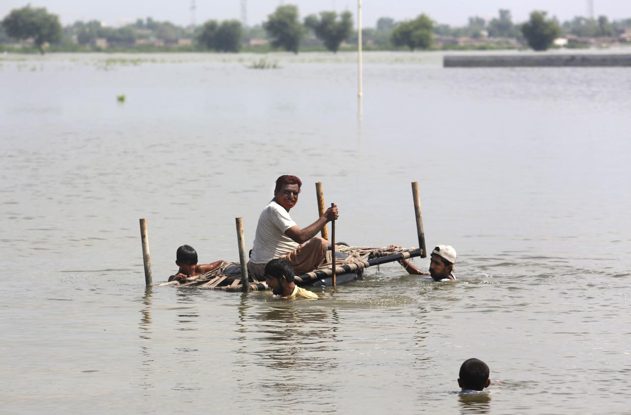 People use cot to salvage belongings from their nearby flooded home caused by heavy rain in Jaffarabad, a district of Pakistan's southwestern Baluchistan province, Saturday, Sep. 3, 2022. 