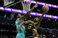 Golden State Warriors forward Andrew Wiggins shoots around Charlotte Hornets center Nick Richards during the first half of an NBA basketball game on Friday, March 29, 2024, in Charlotte, N.C. (AP Photo/Chris Carlson)