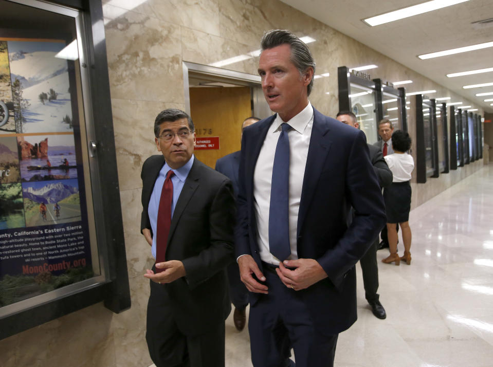 California Gov. Gavin Newsom, right, and Attorney General Xavier Becerra, leave a news conference where they announced the state has filed a lawsuit against the Trump administration's new rules blocking green cards for many immigrants who receive government assistance, in Sacramento, Calif., Friday, Aug. 16, 2019. California, three other states and the District of Columbia filed the suit Friday against some of the administration's most aggressive moves to restrict legal immigration that are supposed to take effect in October. (AP Photo/Rich Pedroncelli)