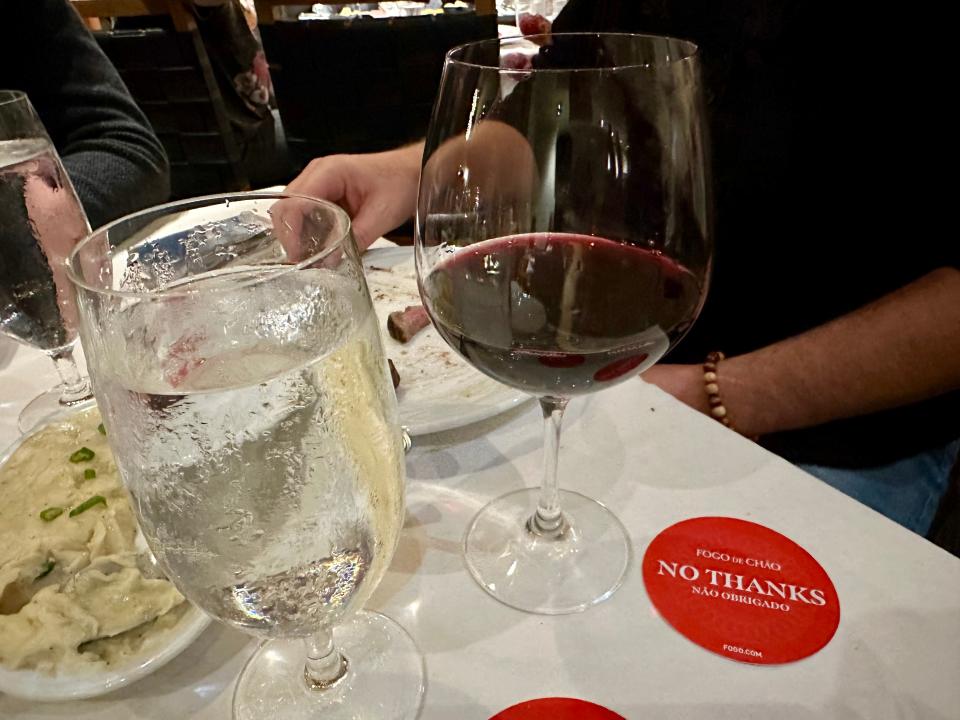 glasses filled with sprite and red wine on a table at fogo de chao