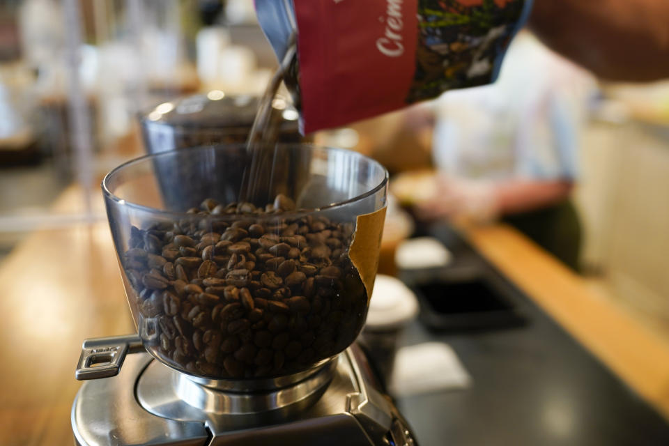 Chris Vigilante refills a coffee grinder with coffee beans at Vigilante Coffee, Wednesday, Sept. 1, 2021, in College Park, Md. A confluence of supply chain problems, drought, frost and inflation all point to the price of your cup of morning coffee going up. The tricky part is trying to figure when — and how much. (AP Photo/Julio Cortez)