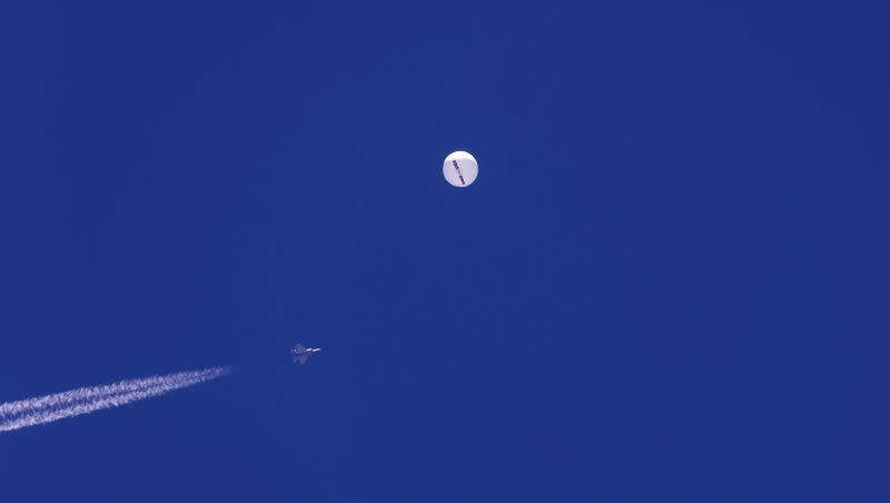 A fighter jet flies near a large balloon drifting above the Atlantic Ocean, just off the coast of South Carolina near Myrtle Beach, Saturday, Feb. 4, 2023. Minutes later, the balloon was struck by a missile from an F-22 fighter jet, ending its weeklong traverse over the U.S. China said the balloon was a weather research vessel blown off course, a claim rejected by U.S. officials.