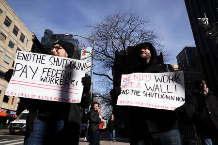 Protestors hold signs during a rally outside a closed federal building in the Manhattan borough of New York City, New York, U.S., January 15, 2019. REUTERS/Carlo Allegri