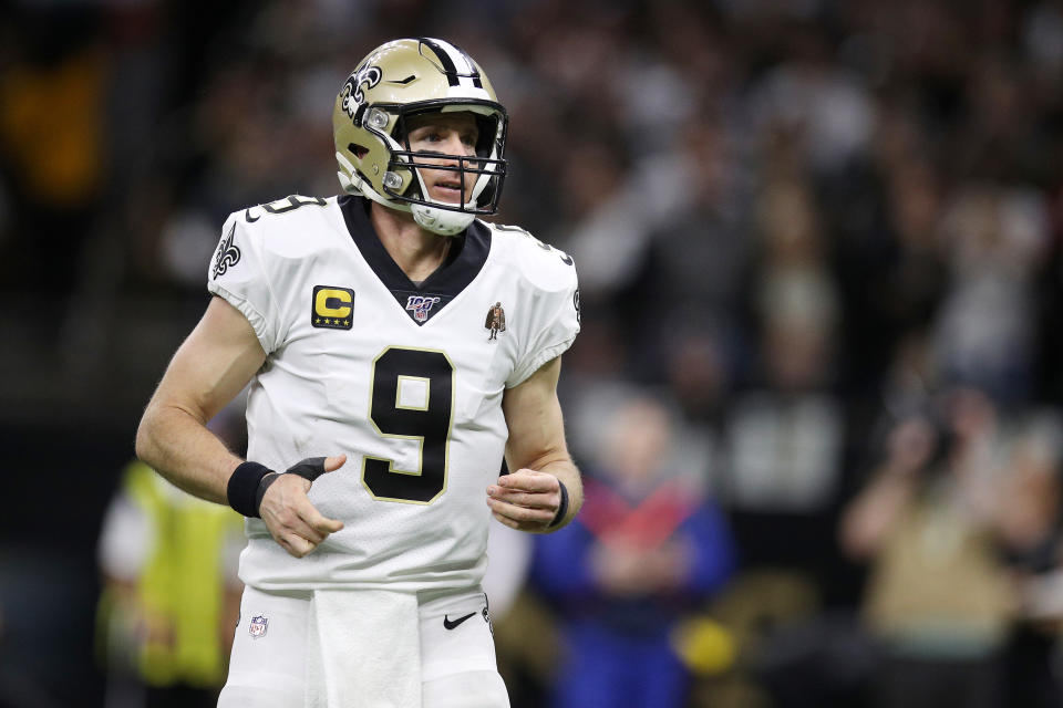 Drew Brees jogs on a football field.