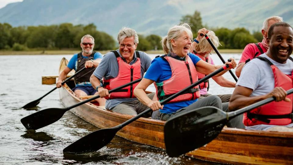 Un alto grupo de amigos disfrutando de remar en el río Derwent