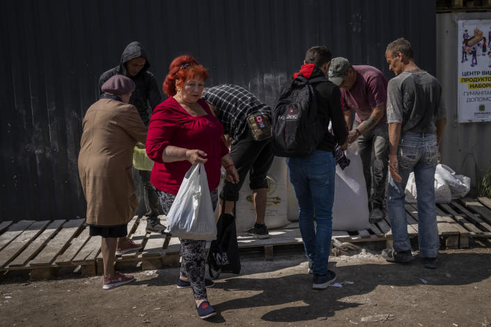 People receive flour at a food donation spot in Kharkiv, eastern Ukraine, Monday, May 23, 2022. (AP Photo/Bernat Armangue)