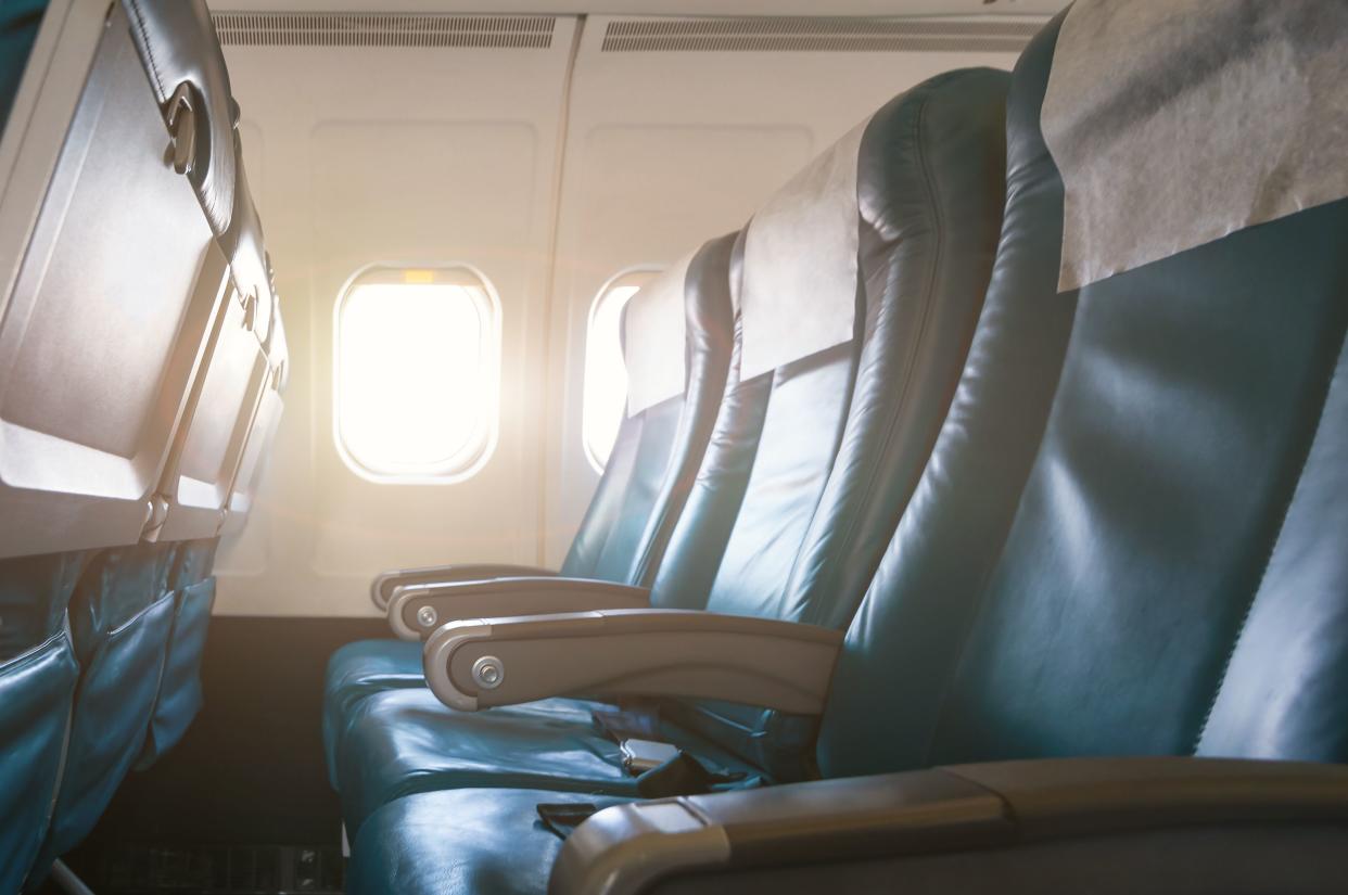 Interior of airplane with empty seats and sunlight at the window. Travel concept.