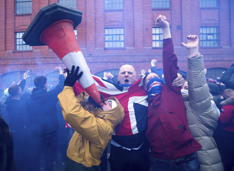 Rangers fans celebrate outside the ground after their win in the Scottish Premiership match against St Mirren, at Ibrox Stadium in Glasgow, Scotland, Saturday March 6, 2021. Some thousands of fans gathered outside the stadium celebrating the win against St. Mirren, putting them on the brink of securing the Scottish Premiership title. (Robert Perry/PA via AP)