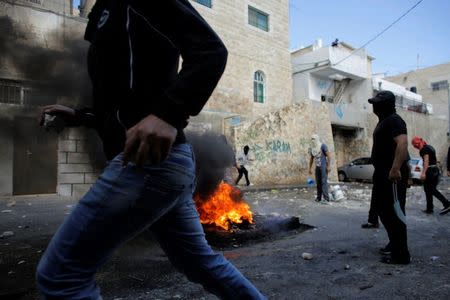 Palestinians are seen during clashes with Israeli police forces in the Abu Tor neighbourhood of east Jerusalem October 30, 2014. REUTERS/Ammar Awad