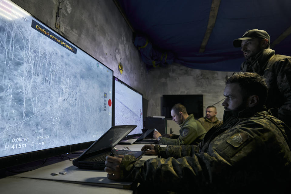 Ukrainian soldiers watch drone feeds from an underground command center in Bakhmut, Donetsk region, Ukraine, Sunday, Dec. 25, 2022. The Ukrainian government minister in charge of technology says his country has bought some 1,400 drones, mostly for reconnaissance, and is now developing air-to-air combat ones that can attack the drones Russia is using against Ukrainians. (AP Photo/Libkos)