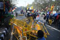 Farmers on a tractor prepare to remove police barricades during a rally as they continue to protest against the central government's recent agricultural reforms in New Delhi on January 26, 2021. (Photo by Sajjad HUSSAIN / AFP) (Photo by SAJJAD HUSSAIN/AFP via Getty Images)