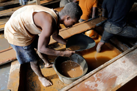 An artisanal miner pans for gold in alluvial sediment over a plastic bucket at the unlicensed mining site of Nsuaem Top in Ghana, November 23, 2018. REUTERS/Zohra Bensemra